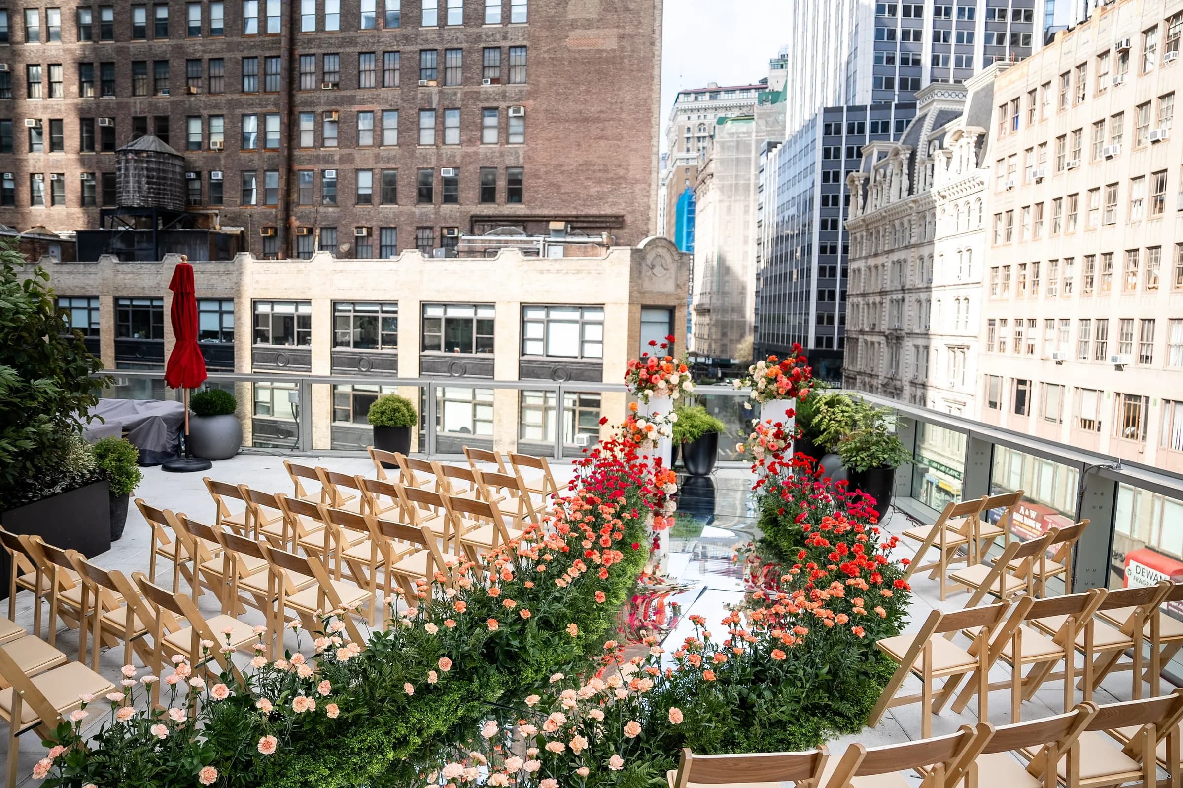 Rooftop ceremony aisle lined with carnations above Manhattan